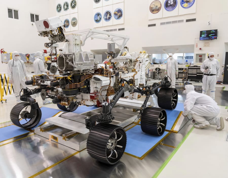 FILE - In this Dec. 17, 2019, file photo made available by NASA, engineers watch the first driving test for the Mars 2020 rover Perseverance. in a clean room at the Jet Propulsion Laboratory in Pasadena, Calif. NASA has delayed the launch of its newest Mars rover yet again because of rocket issues. The space agency has until mid-August to send the Perseverance rover to the red planet to look for signs of ancient microscopic life, before having to wait until 2022. Managers are now targeting no earlier than July 30 for a liftoff from Cape Canaveral, Florida, eating up half of the month-long launch window. (J.