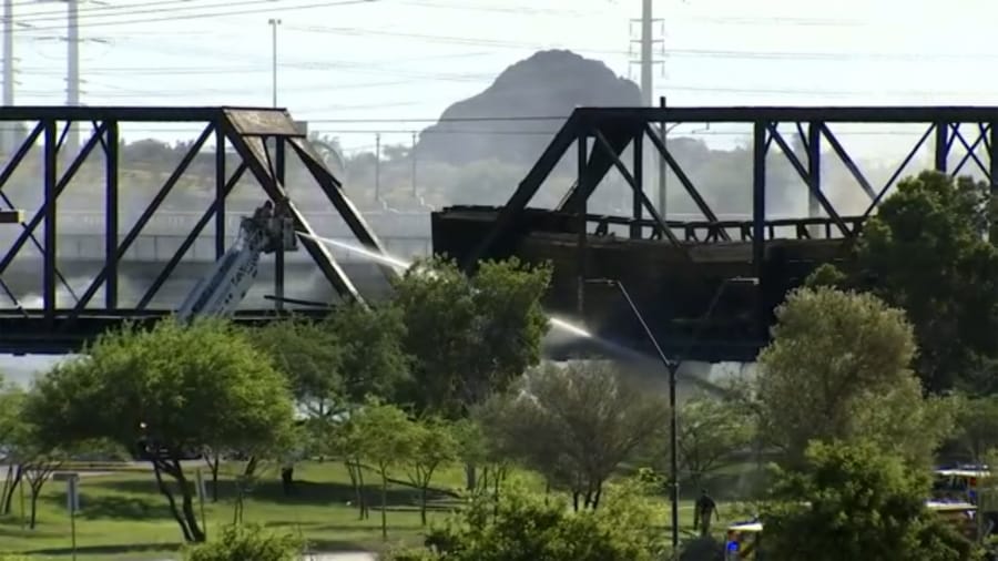 Smoke fills the sky at the scene of a train derailment in Tempe, Ariz., on Wednesday, July 29, 2020. Officials say a freight train traveling on a bridge that spans a lake in the Phoenix suburb derailed and set the bridge ablaze and partially collapsing the structure.  There were no immediate reports of any leaks.