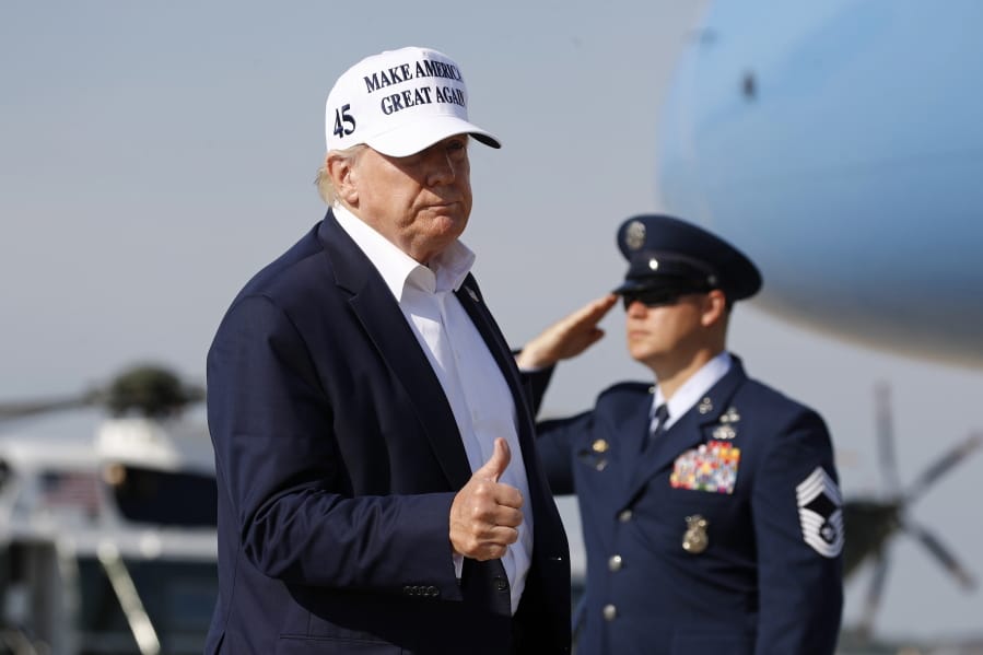 President Donald Trump gestures as he steps off Air Force One at Andrews Air Force Base, Md., Sunday, July 26, 2020. Trump is returning to Washington after spending the weekend at his golf club in Bedminster, N.J.