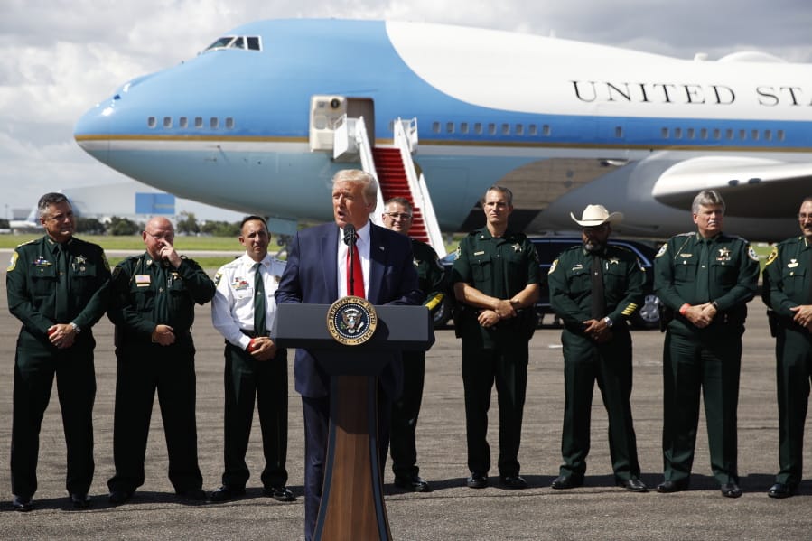 With Air Force One in the background, President Donald Trump speaks during a campaign event with Florida Sheriffs in Tampa, Fla., Friday, July 31, 2020.