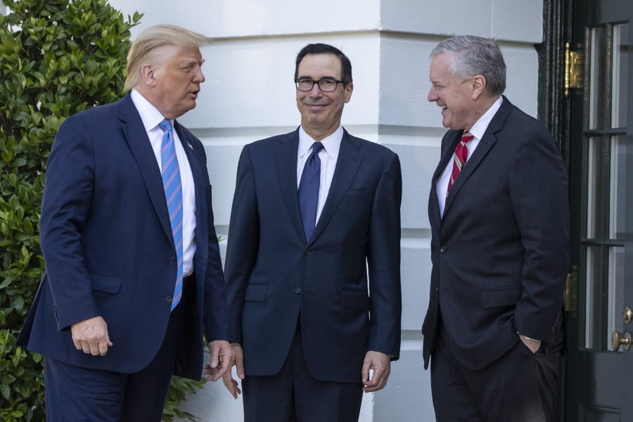President Donald Trump, Treasury Secretary Steven Mnuchin, White House Chief of Staff Mark Meadows talk before Trump speaks with reporters on the South Lawn of the White House, Wednesday, July 29, 2020, in Washington. Trump is en route to Texas.