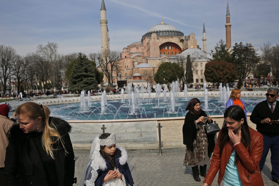 People walk in 2017 backdropped by the Byzantine-era Hagia Sophia, one of Istanbul&#039;s main tourist attractions, in the historic Sultanahmet district of Istanbul. The 6th-century building is now at the center of a heated debate between conservative groups who want it to be reconverted into a mosque and those who believe the World Heritage site should remain a museum.