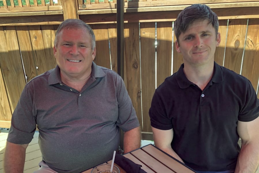 Buck Newsome, left, a baby boomer, and his son, Chris Newsome, of the millennial generation, have lunch together June 26 in Newtown, Ohio. American&#039;s two largest generations can agree on something: the coronavirus pandemic has hit them both hard.