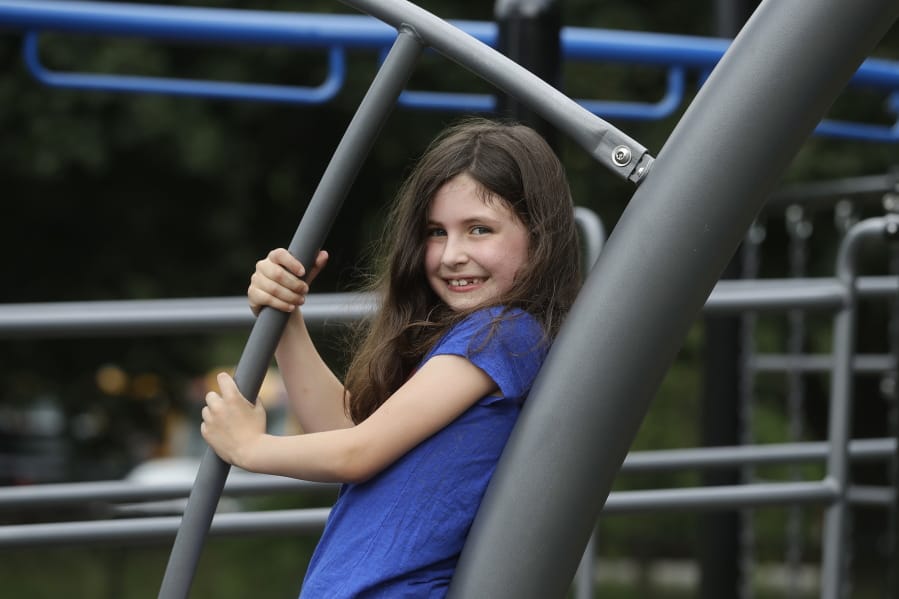 Sophia Garabedian, 6, of Sudbury, Mass., who contracted Eastern Equine Encephalitis in 2019, stands for a photograph on a playground, Wednesday, July 8, 2020, in Sudbury. As the coronavirus pandemic subsides for now in the hard hit Northeast, public health officials in the region are bracing for another mysterious virus: Eastern Equine Encephalitis, or EEE, a rare but severe mosquito-borne virus.