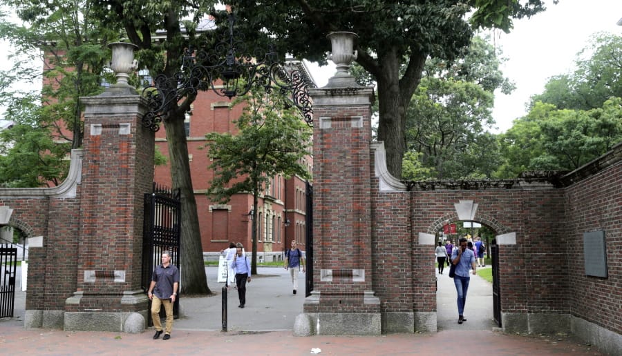 FILE - In this Aug. 13, 2019, file photo, pedestrians walk through the gates of Harvard Yard at Harvard University in Cambridge, Mass. Harvard and the Massachusetts Institute of Technology filed a federal lawsuit Wednesday, July 8, 2020, challenging the Trump administration&#039;s decision to bar international students from staying in the U.S. if they take classes entirely online this fall. Some institutions, including Harvard, have announced that all instruction will be offered remotely in the fall during the ongoing coronavirus pandemic.