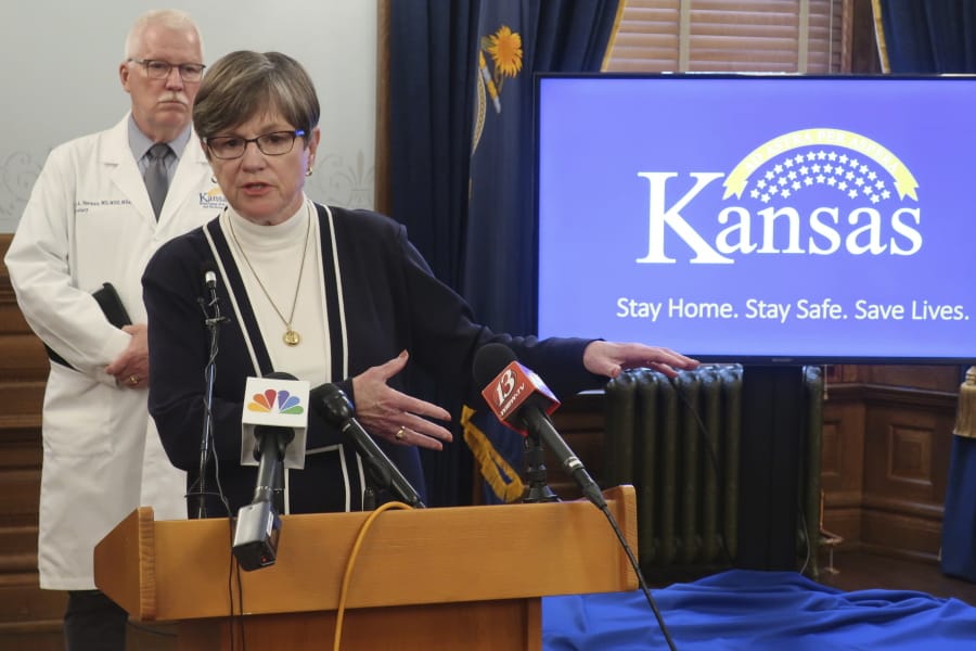 Kansas Gov. Laura Kelly answers questions about the state&#039;s response to the coronavirus pandemic as Dr. Lee Norman, her health secretary, watches behind her, Monday, June 8, 2020, at the Statehouse in Topeka, Kan. Kelly the state&#039;s counties &quot;shouldn&#039;t feel pressure&quot; to lift restrictions further if they&#039;re not seeing new cases and new hospitalizations decline.