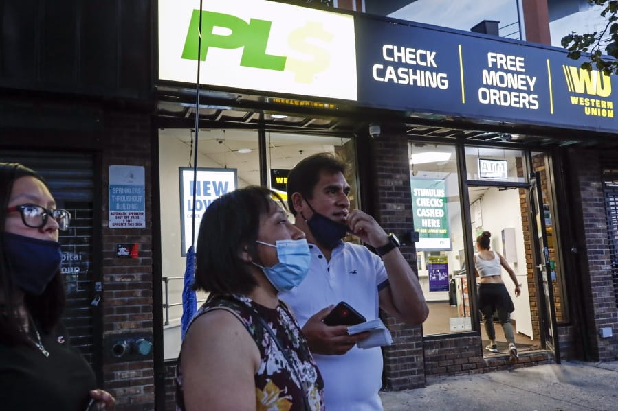 Magnolia Ortega, center, stands outside a Western Union with her husband Arturo Morales and their daughter Marlene after wiring money to her family in Mexico, Wednesday, June 24, 2020, in Staten Island, New York. Ortega lost her job cleaning houses amid the COVID-19 pandemic, reducing the monthly amount she sends home. She&#039;s considering returning to her hometown of San Jeronimo Xayacatlan but says there&#039;s no work there either and that would mean one less family member sending back one less monthly check.