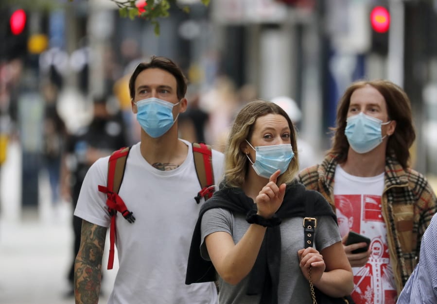 Shoppers wearing protective face masks walk along Oxford Street in London, Tuesday, July 14, 2020.Britain&#039;s government is demanding people wear face coverings in shops as it has sought to clarify its message after weeks of prevarication amid the COVID-19 pandemic.