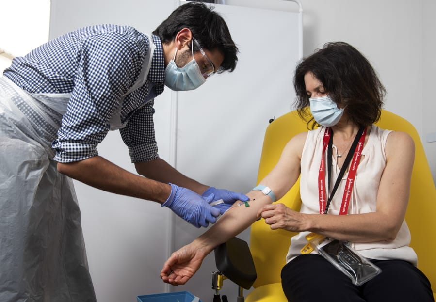 In this handout photo released by the University of Oxford a doctor takes blood samples for use in a coronavirus vaccine trial in Oxford, England, Thursday June 25, 2020. Scientists at Oxford University say their experimental coronavirus vaccine has been shown in an early trial to prompt a protective immune response in hundreds of people who got the shot. In research published Monday July 20, 2020 in the journal Lancet, scientists said that they found their experimental COVID-19 vaccine produced a dual immune response in people aged 18 to 55. British researchers first began testing the vaccine in April in about 1,000 people, half of whom got the experimental vaccine.