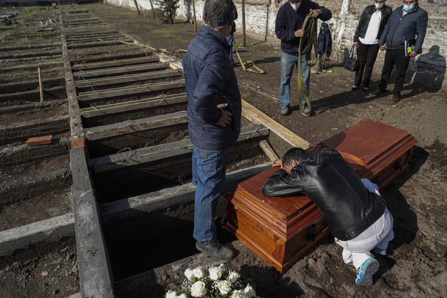Peruvian migrant Jose Collantes grieves as he cries on the coffin that contains the remains of his wife Silvia Cano, who died due to COVID-19 complications, according to Collantes, at a Catholic cemetery in Santiago, Chile, Friday, July 3, 2020.