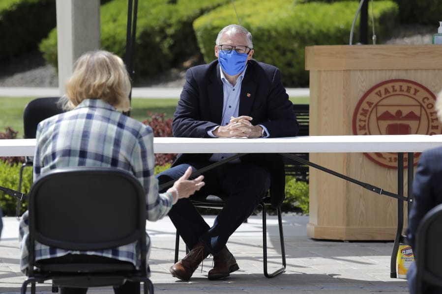 Washington state Gov. Jay Inslee listens at an outdoor round table meeting with leaders in local government, health care and business talking about the high rate of coronavirus cases in the area at Yakima Valley College Tuesday, June 16, 2020, in Yakima, Wash. Inslee met to discuss the impact of the COVID-19 pandemic in the area, which has one of the highest rates of infection in the state.