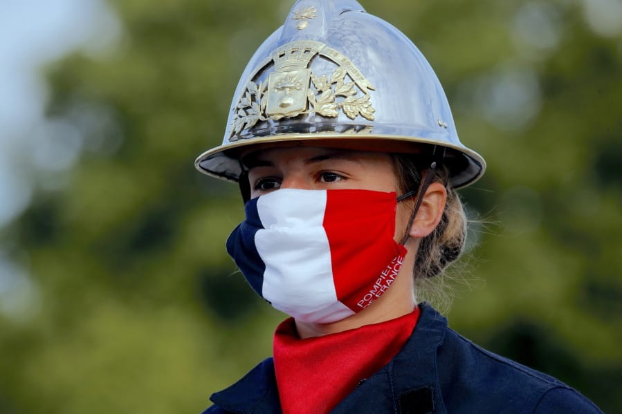 A firefighter wears a face mask with the colors of the French flag, prior to the Bastille Day parade July 14 on the Champs-Elysees avenue in Paris.