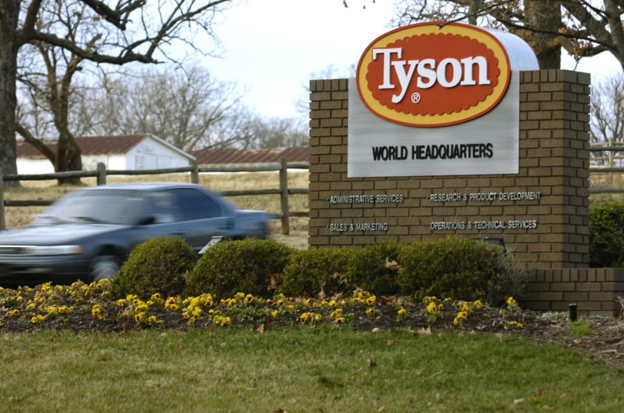 FILE - In this Jan. 29, 2006, file photo, a car passes in front of a Tyson Foods Inc., sign at Tyson headquarters in Springdale, Ark.  Tyson Foods plans to administer thousands of coronavirus tests per week at its U.S. facilities under an expanded effort to protect workers and keep plants running. The Springdale, Arkansas-based company, which processes about 20% of all beef, pork and chicken in the U.S., on Wednesday, July 29, 2020, said it will randomly test employees who have no symptoms as well as those with symptoms   (AP Photo/April L.