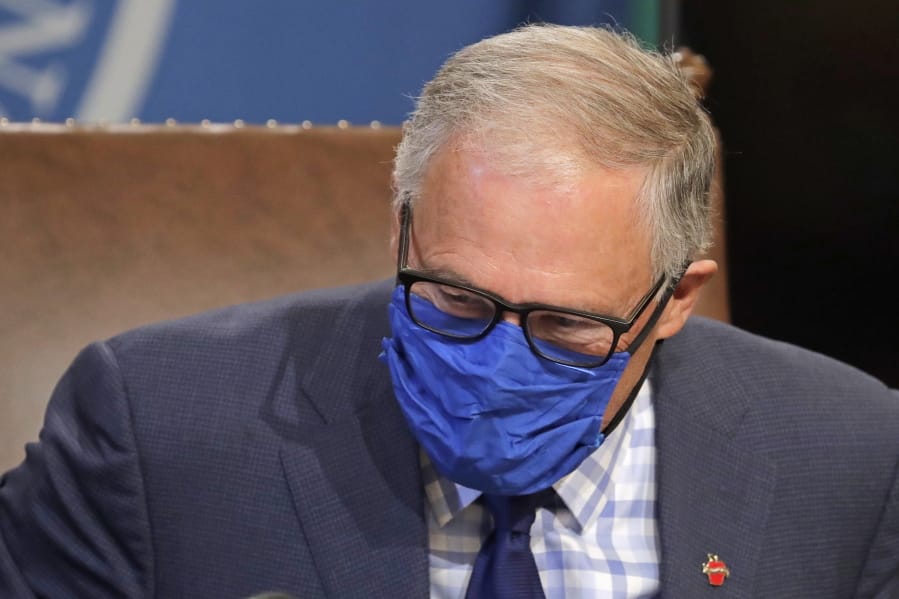 Washington Gov. Jay Inslee wears a face mask as he concludes a news conference, Tuesday, June 23, 2020, at the Capitol in Olympia, Wash. Inslee announced Tuesday that Washington state will require people to wear facial coverings in most indoor and outdoor public settings, under a statewide public health order in response to ongoing COVID-19 related health concerns. (AP Photo/Ted S.
