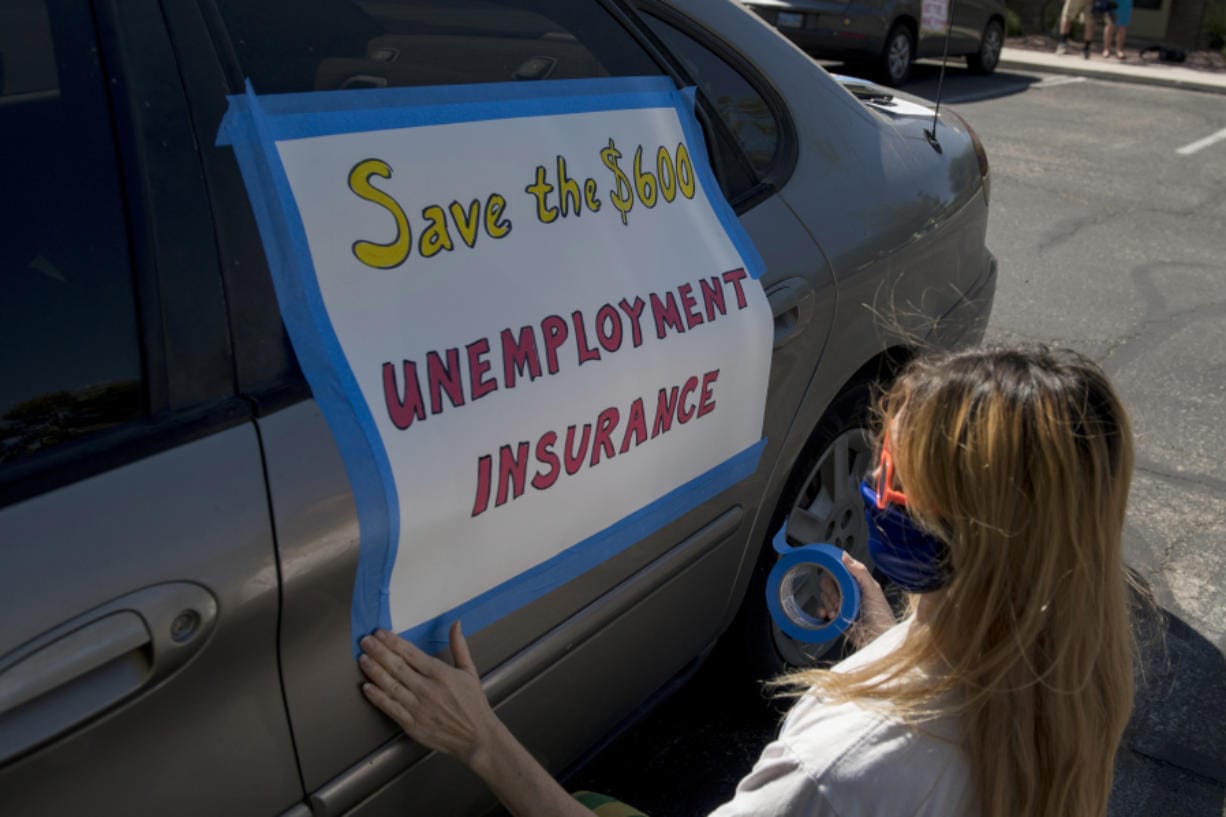 In this file photo, Francis Stallings tapes signs to her car before participating in a caravan rally down the Las Vegas Strip in support of extending the $600 unemployment benefit, August 6, 2020 in Las Vegas, Nevada. Stateline analysis of Department of Labor data released last week and other federal statistics suggests that even as some businesses reopen, unemployment is rising again in seven states (California, Indiana, Kansas, Mississippi, Nevada, New Mexico and Wyoming) and is basically unchanged in 22 others, plus the District of Columbia.