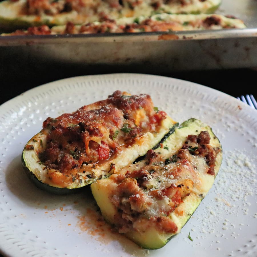 Zucchini stuffed with spicy sausage, fresh tomatoes and cheese is full of summer flavors.