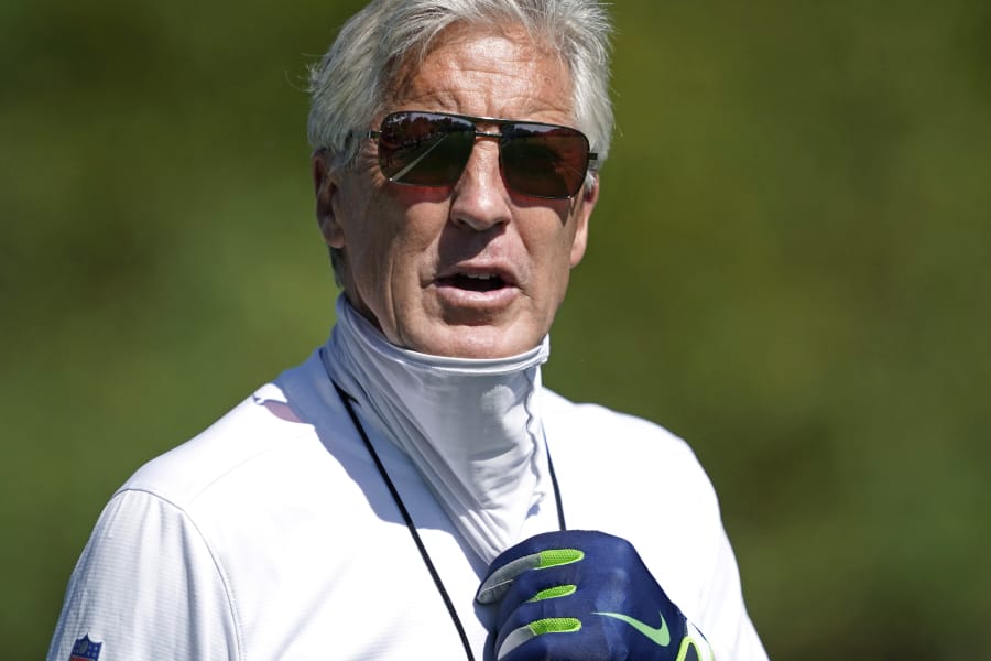 Seattle Seahawks head coach Pete Carroll briefly pulls down his face covering during NFL football training camp, Monday, Aug. 24, 2020, in Renton, Wash. (AP Photo/Ted S.
