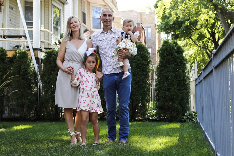 Vahap Sarac, right, holding daughter Ella, 1, his wife Rita Sarac and daughter  Ada, 6, in Chicago&#039;s Albany Park neighborhood on August 12, 2020. Sarac who worked as a banquet captain at the Palmer House until he was laid off in March. His health insurance, which covers him, his wife and two kids, is set to expire in October, at which point he&#039;s not sure what he&#039;ll do. He and his wife have even discussed sending the kids to live with their grandparents in Estonia, where there are fewer COVID cases and universal health care. (Jose M.