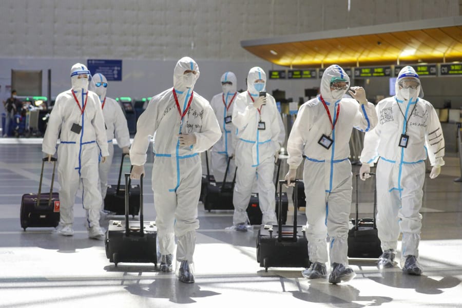 A flight crew in full biohazard suits at Tom Bradley International Terminal at LAX on Friday, May 22, 2020 in Los Angeles, Calif. Qian Lang, the first confirmed case of COVID-19 in Los Angeles, remained the sole patient diagnosed with the virus here for five weeks, passing most of that time in top-secret isolation at Cedars-Sinai Medical Center.