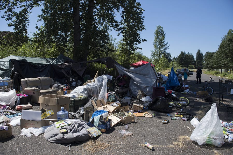 Officer Tyler Chavers stops to check on residents of a homeless encampment in northeast Vancouver in July.