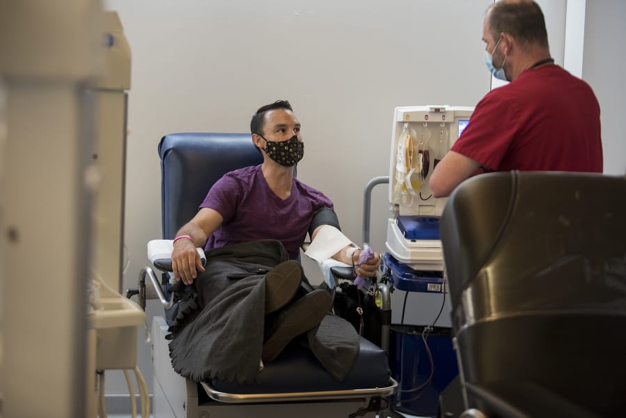 Michael Chubbuck of Portland, left, donates convalescent plasma, which is collected from COVID-19 survivors that contain antibodies, while chatting with apheresis tech Brendan Turnbull at the Red Cross Portland donation center Wednesday morning. Local blood banks are encouraging residents in the Portland-Vancouver metro area who have recovered from COVID-19 to visit a branch and donate plasma to aid researchers in finding a cure.