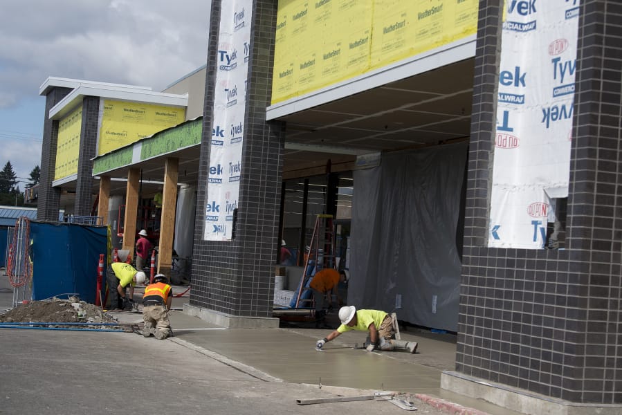Construction workers bring a new Grocery Outlet store to life at Evergreen Plaza on Wednesday. The location is a former Salvation Army thrift store.
