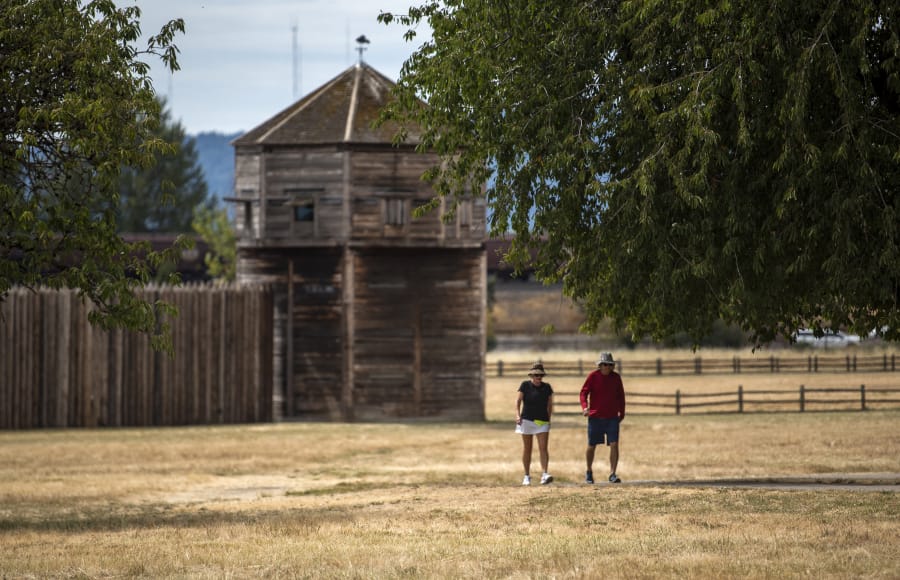 Tami Nesburg, left, and her co-worker Randy Krenelka take a walk during their lunch break Thursday at Fort Vancouver National Historic Site. Attractions such as the visitor center, reconstructed Fort Vancouver and Pearson Air Museum are closed, but the parking lots and walking paths are open.