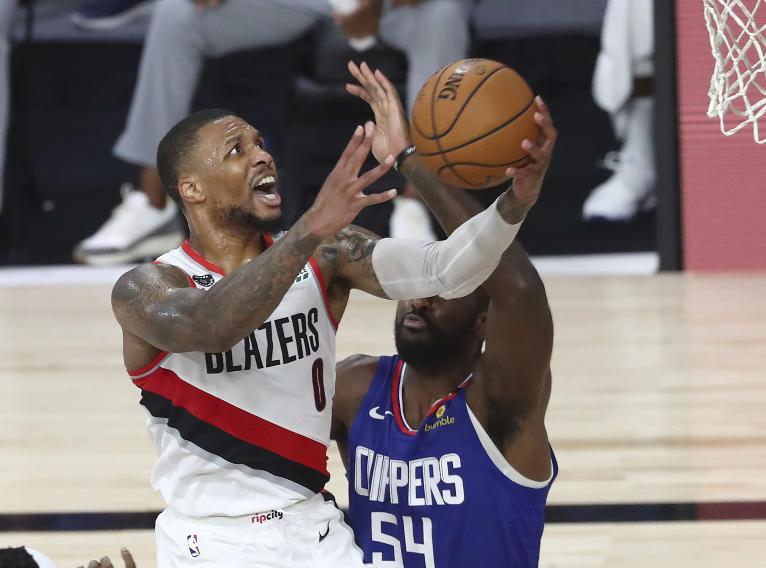 Portland Trail Blazers guard Damian Lillard (0) shoots past Los Angeles Clippers' Patrick Patterson (54) during the second half in an NBA basketball game Saturday, Aug. 8, 2020, in Lake Buena Vista, Fla.