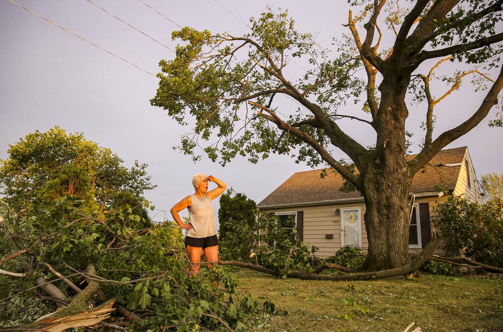 Laurie Berdahl stands in her front yard beginning to clean up downed limbs around her home, Monday, Aug. 10, 2020, in Cedar Rapids, Iowa. Berdahl's home suffered only minor damage but like most of the city she was without power.