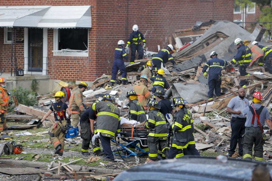 Baltimore City Fire Department carries a person out from the debris after an explosion in Baltimore on Monday, Aug. 10, 2020. Baltimore firefighters say an explosion has levelled several homes in the city.
