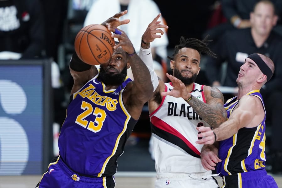 Los Angeles Lakers forward LeBron James (23) and Los Angeles Lakers guard Alex Caruso, right, battle Portland Trail Blazers guard Gary Trent Jr. (2) for control of the ball during the first half of an NBA basketball first round playoff game, Saturday, Aug. 22, 2020, in Lake Buena Vista, Fla.