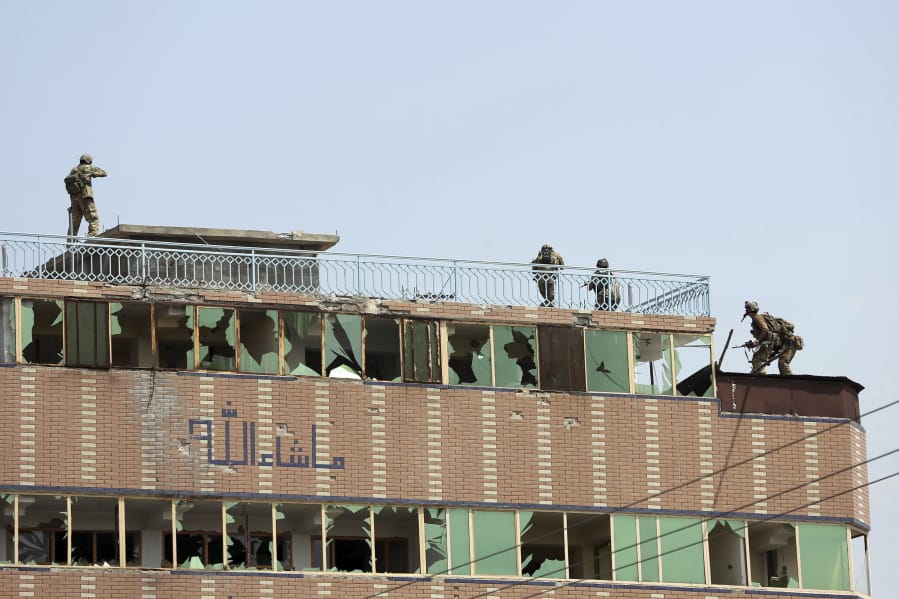 Afghan security personnel take position on the top of a building where insurgents were hiding, in the city of Jalalabad, east of Kabul, Afghanistan, Monday, Aug. 3, 2020. An Islamic State group attack on a prison in eastern Afghanistan holding hundreds of its members raged on Monday after killing people in fighting overnight, a local official said.