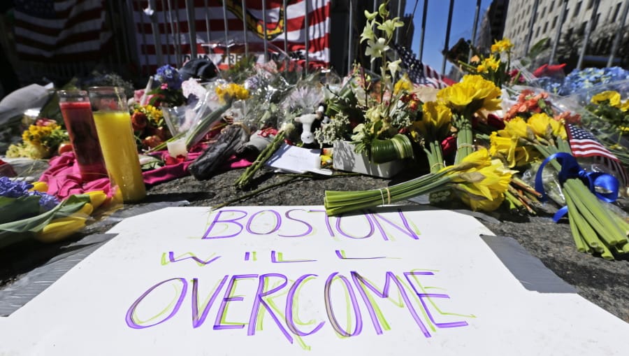 FILE - In this April 17, 2013 photograph, flowers and signs adorn a barrier, two days after two explosions killed three and injured hundreds, at Boylston Street near the of finish line of the Boston Marathon at a makeshift memorial for victims and survivors of the bombing.  A federal appeals court has overturned the death sentence of Dzhokhar Tsarnaev in the 2013 Boston Marathon bombing, Friday, July 31, 2020, saying the judge who oversaw the case didn&#039;t adequately screen jurors for potential biases.