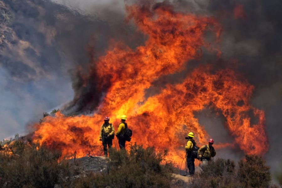 Firefighters watch the Apple Fire in Banning, Calif., Sunday, Aug. 2, 2020. (AP Photo/Ringo H.W.