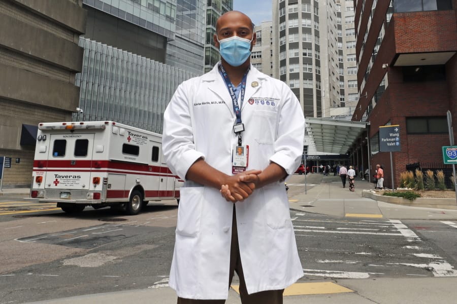 Alister Martin, an emergency room doctor at Massachusetts General Hospital, poses outside the hospital, Friday, Aug. 7, 2020, in Boston. Martin founded the organization &quot;VotER&quot; to provide medical professionals voter registration resources for patients who are unregistered voters.