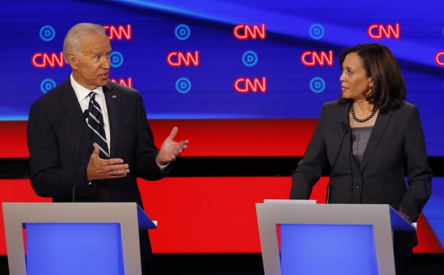 FILE - In this July 31, 2019, file photo, then-Democratic presidential candidate Sen. Kamala Harris, D-Calif., listens as Democratic presidential candidate former Vice President Joe Biden speaks during a Democratic presidential primary debate at the Fox Theatre in Detroit. Democratic presidential candidate former Vice President Joe Biden has chosen Harris as his running mate.