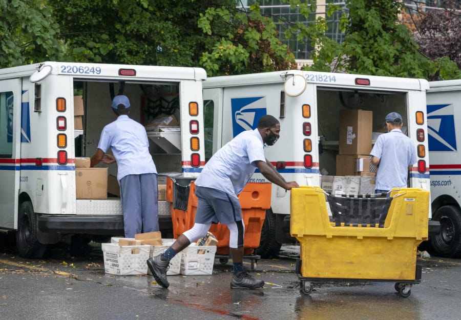FILE - In this July 31, 2020, file photo, letter carriers load mail trucks for deliveries at a U.S. Postal Service facility in McLean, Va. The success of the 2020 presidential election could come down to a most unlikely government agency: the U.S. Postal Service.  (AP Photo/J. Scott Applewhite, File) (j.