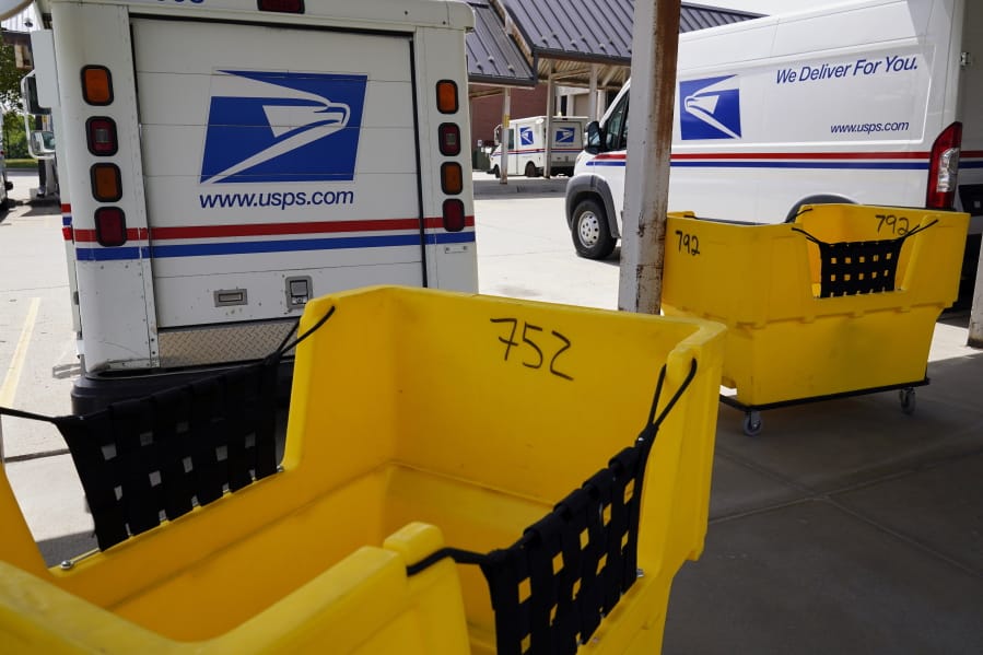 Mail delivery vehicles are parked outside a post office in Boys Town, Neb., Tuesday, Aug. 18, 2020. The Postmaster general announced Tuesday he is halting some operational changes to mail delivery that critics warned were causing widespread delays and could disrupt voting in the November election.