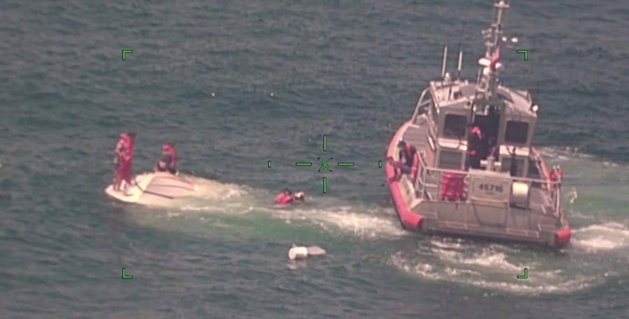 In this photo released by the U.S. Coast Guard, members of the Coast Guard rescue a family of four, Wednesday, Aug. 5, 2020, from a vessel taking on water 17 miles south of Southwest Pass near Venice, La. (U.S.