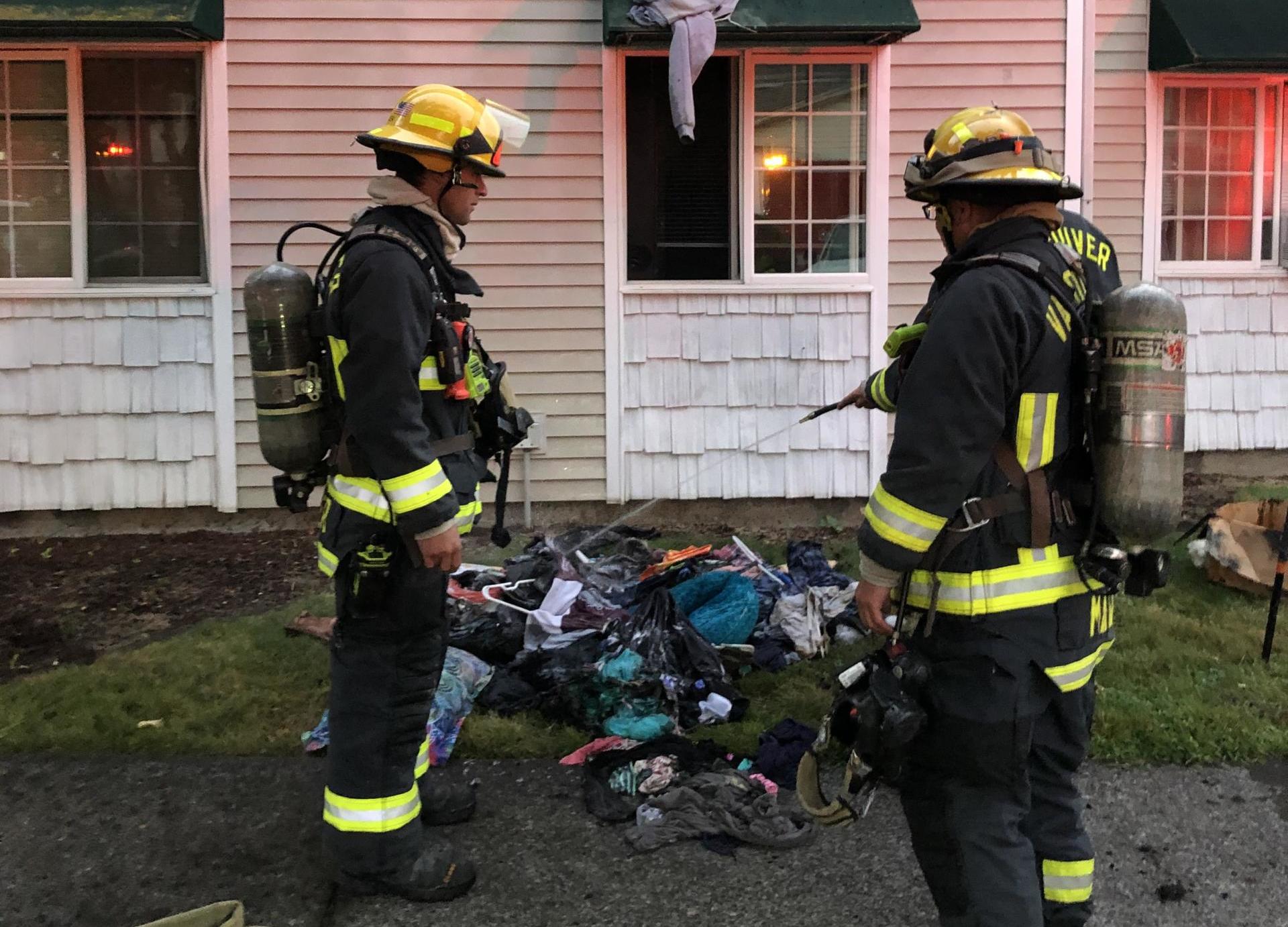 Vancouver firefighters wet down clothing that had caught fire in an apartment closet.