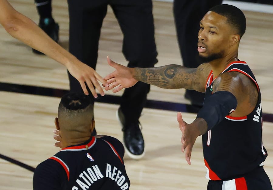 Portland Trail Blazers&#039;: Damian Lillard, right,celebrates against the Memphis Grizzlies during the first half of an NBA basketball game Saturday, Aug. 15, 2020, in Lake Buena Vista, Fla. (Kevin C.
