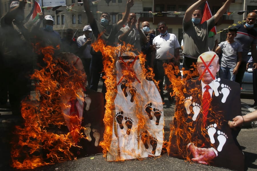 Palestinians burn pictures of U.S. President Donald Trump, Abu Dhabi Crown Prince Mohammed bin Zayed al-Nahyan and and Israeli Prime Minister Benjamin Netanyahu during a protest against the United Arab Emirates&#039; deal with Israel, in the West Bank city of Nablus, Friday, Aug.