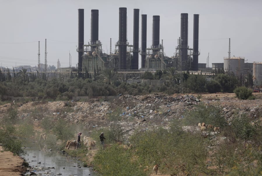 Palestinian shepherds walk with their sheep in front of Gaza&#039;s power plant after it was shutdown according to Gaza&#039;s Hamas officials, in the town of Nusairat, central Gaza Strip, Tuesday, Aug.
