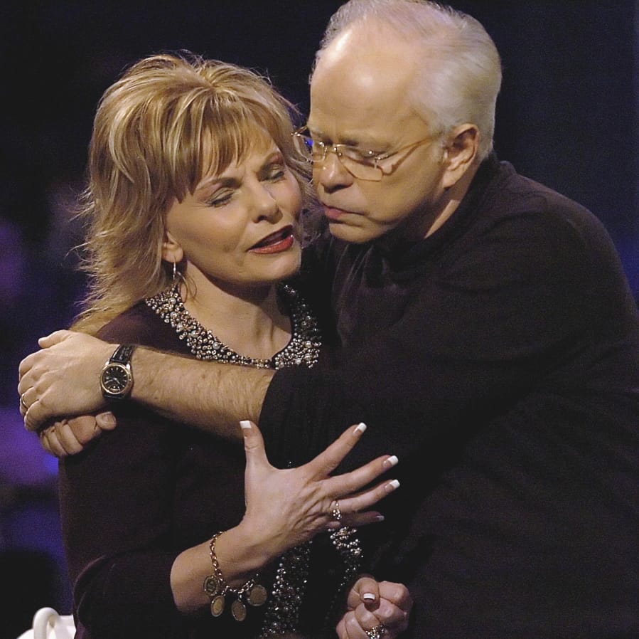 FILE - In this Friday, Dec. 30, 2005 file photo, televangelist Jim Bakker, founder of the former Heritage USA resort, holds his wife, Lori Graham Bakker, as they pray following his sermon, during the MorningStar Fellowship Church New Year&#039;s Conference, in Fort Mill, S.C. Bakker gained notoriety in the late 1980s and 1990s as a result of his trial and financial fraud conviction relating to Heritage USA. He moved to southwest Missouri in 2003.