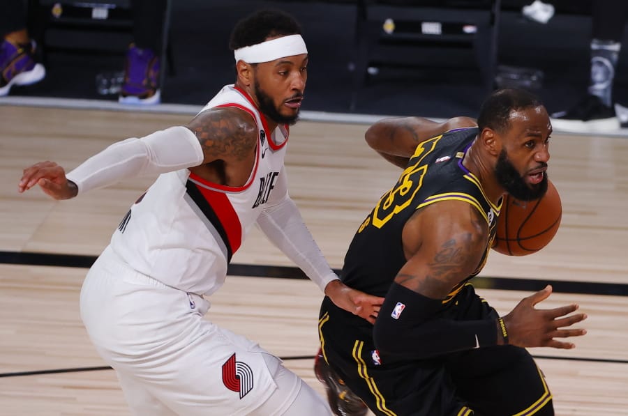 Los Angeles Lakers&#039; LeBron James, right, drives against Portland Trail Blazers&#039; Carmelo Anthony, left, during the second quarter of Game 4 of an NBA basketball first-round playoff series, Monday, Aug. 24, 2020, in Lake Buena Vista, Fla. (Kevin C.