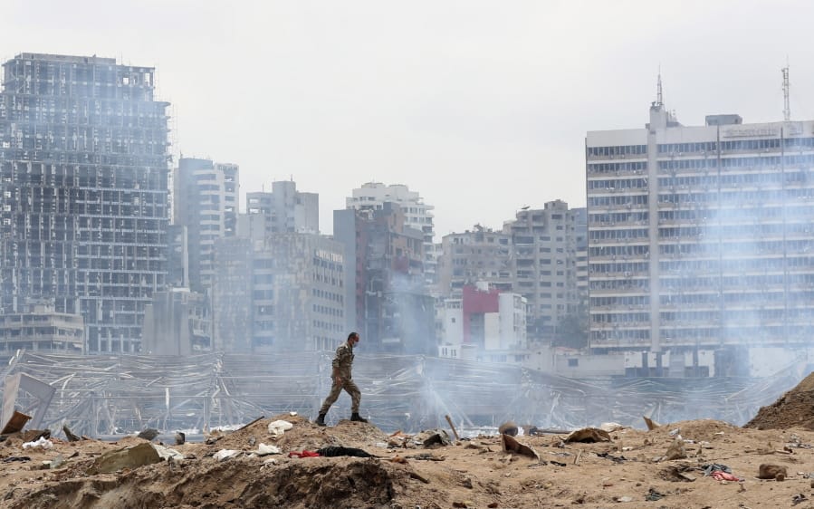 A soldier walks at the devastated site of the explosion in the port of Beirut, Lebanon, Thursday Aug.6, 2020.
