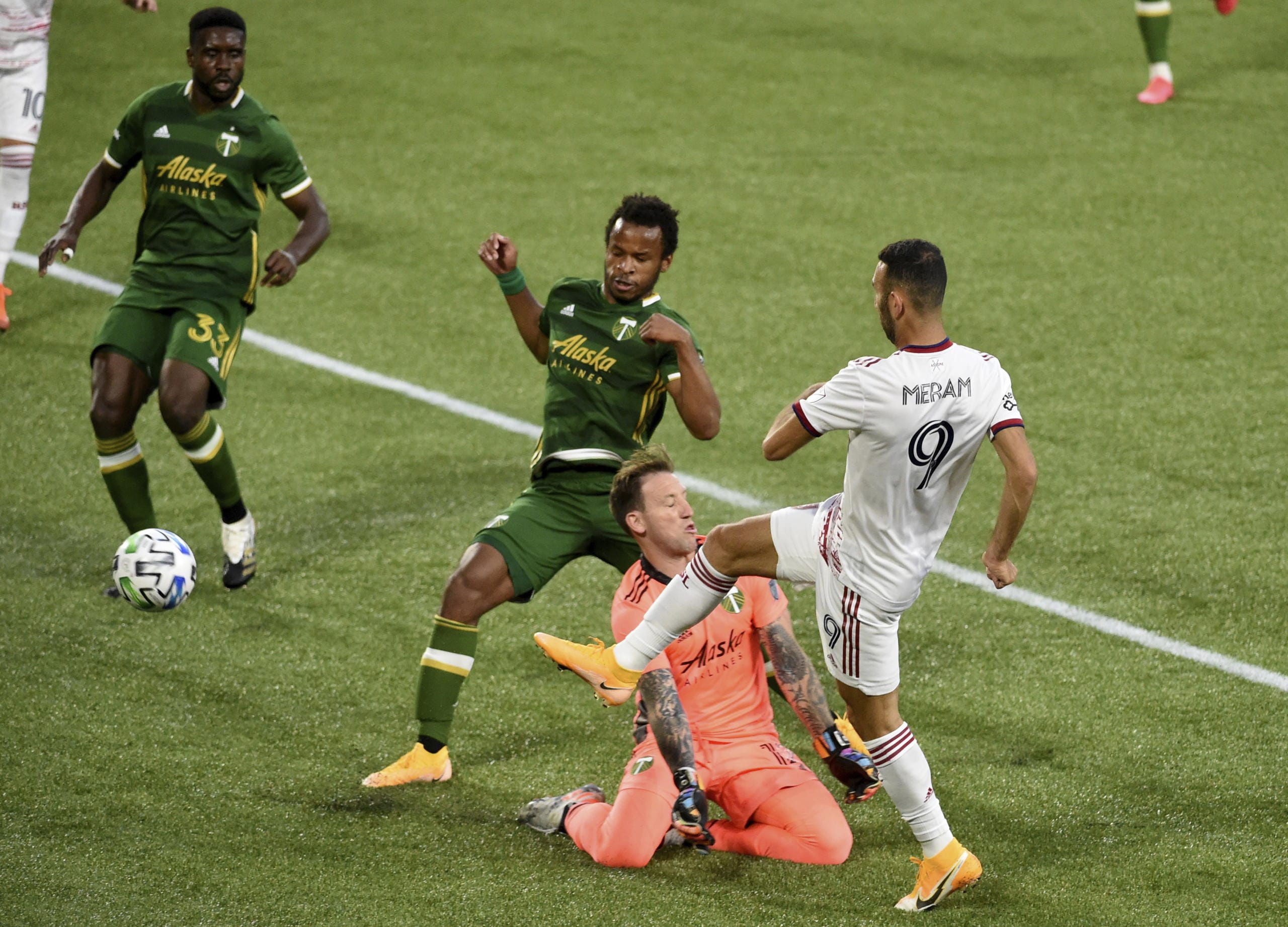 Real Salt Lake forward Justin Meram, right puts a shot on goal as Portland Timbers goalkeeper Steve Clark and forward Jeremy Ebobisse, center, defend and Timbers defender Larrys Mabiala looks at the ball at his feet during the first half of an MLS soccer match in Portland, Ore., Saturday, Aug. 29, 2020.