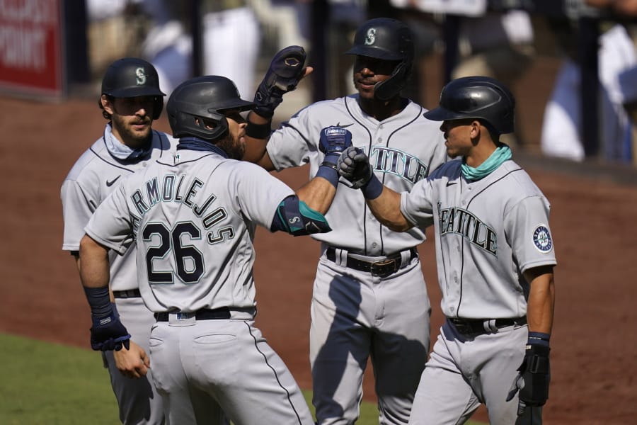 Seattle Mariners&#039; Jose Marmolejos (26) is greeted by teammates Austin Nola, left, Kyle Lewis, second from right, and Sam Haggerty, right, after hitting a grand slam during the first inning of a baseball game against the San Diego Padres, Thursday, Aug. 27, 2020, in San Diego.