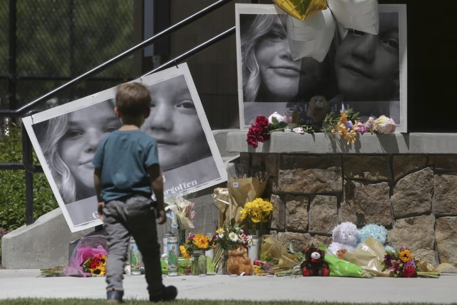 FILE - In this June 11, 2020, file photo, a boy looks at a memorial for Tylee Ryan, 17, and Joshua &quot;JJ&quot; Vallow, 7, at Porter Park in Rexburg, Idaho. An Idaho prosecutor is expected Monday, Aug. 3, 2020, to begin sketching out his case against an Idaho couple at the center of a bizarre missing children&#039;s case that ended in tragedy when their bodies were found buried on a rural eastern Idaho property earlier this year.