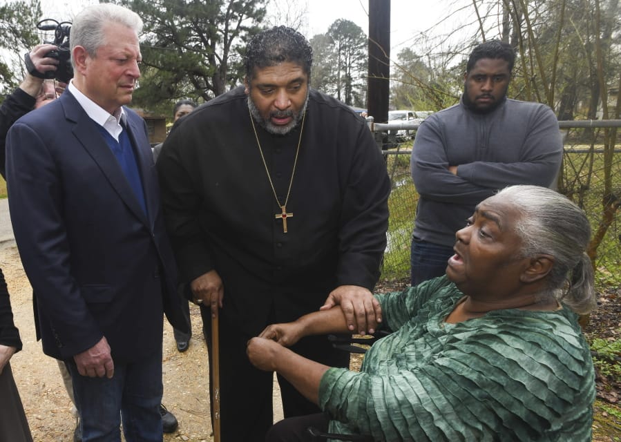 FILE - In this Feb. 21, 2019, file photo, former Vice President Al Gore, left, founder of the Climate Reality Project, and the Rev. William Barber II, president of the Repairers of the Breach, visit Lowndes County resident Charlie Mae Holcombe to talk about the failing wastewater sanitation system at her home in Hayneville, Ala. An anti-poverty coalition led by Barber is scheduled to hold a virtual march Saturday. The Mass Poor People&#039;s Assembly &amp; Moral March on Washington aims to build upon the nation&#039;s principles to pursue solutions to poverty -- something advocates say is getting especially severe in rural areas.